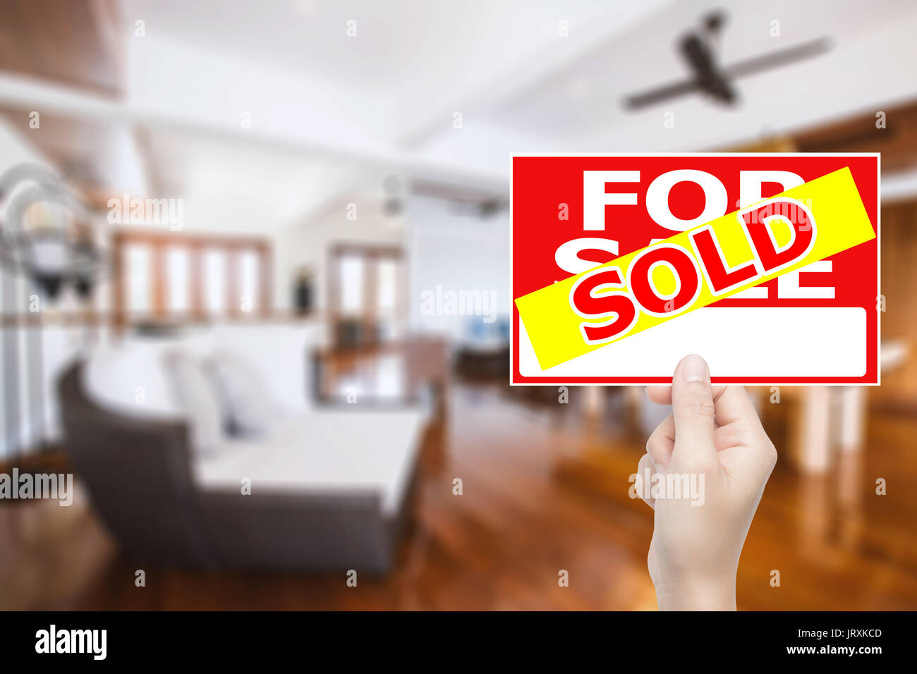hand holding sold house sign Stock Photo