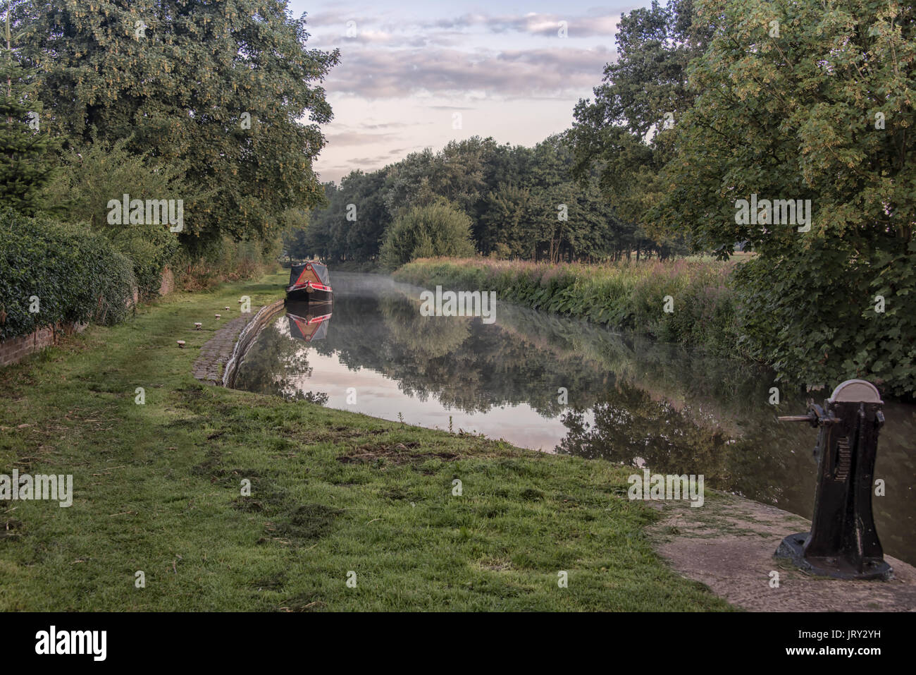 Early morning mist over the Trent and Mersey canal with reflections in the water Stock Photo
