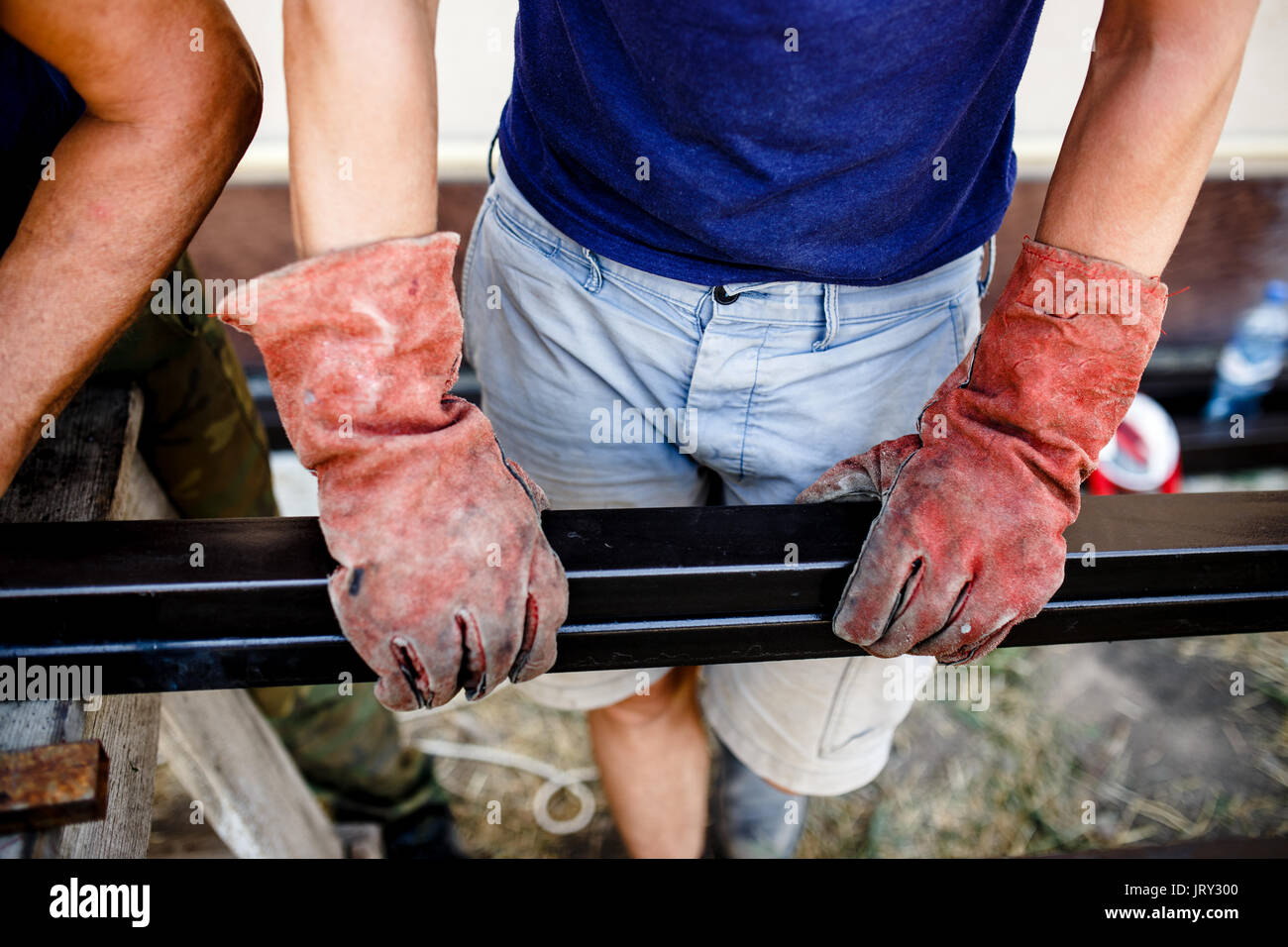 Man measuring off metal bar in workshop. Stock Photo