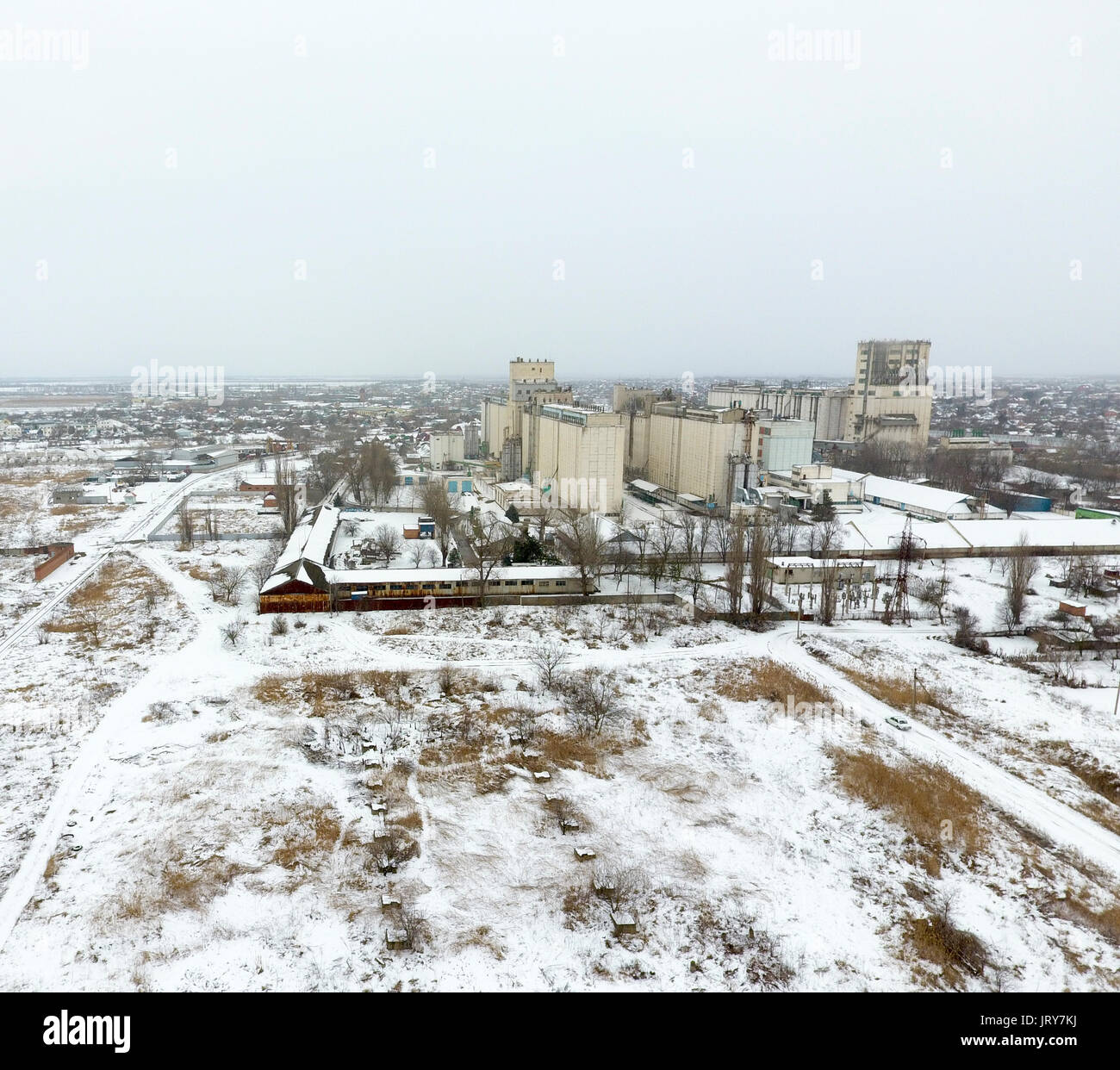 Sprinkled with snow grain elevator. Winter view of the old Soviet elevator. Winter view from the bird's eye view of the village. The streets are cover Stock Photo