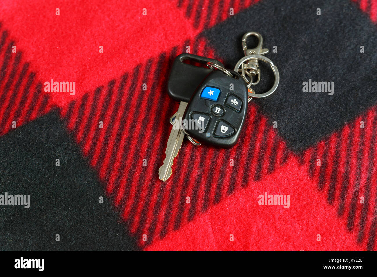 Keys from the car on the red fabric Car key and alarm system charm background Stock Photo