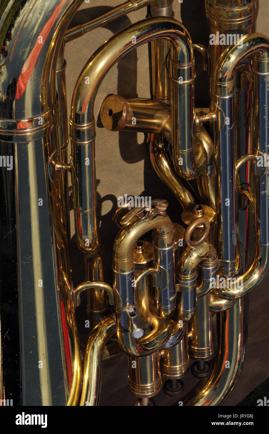 Close up of a brass musical instrument with valves and tuning slides