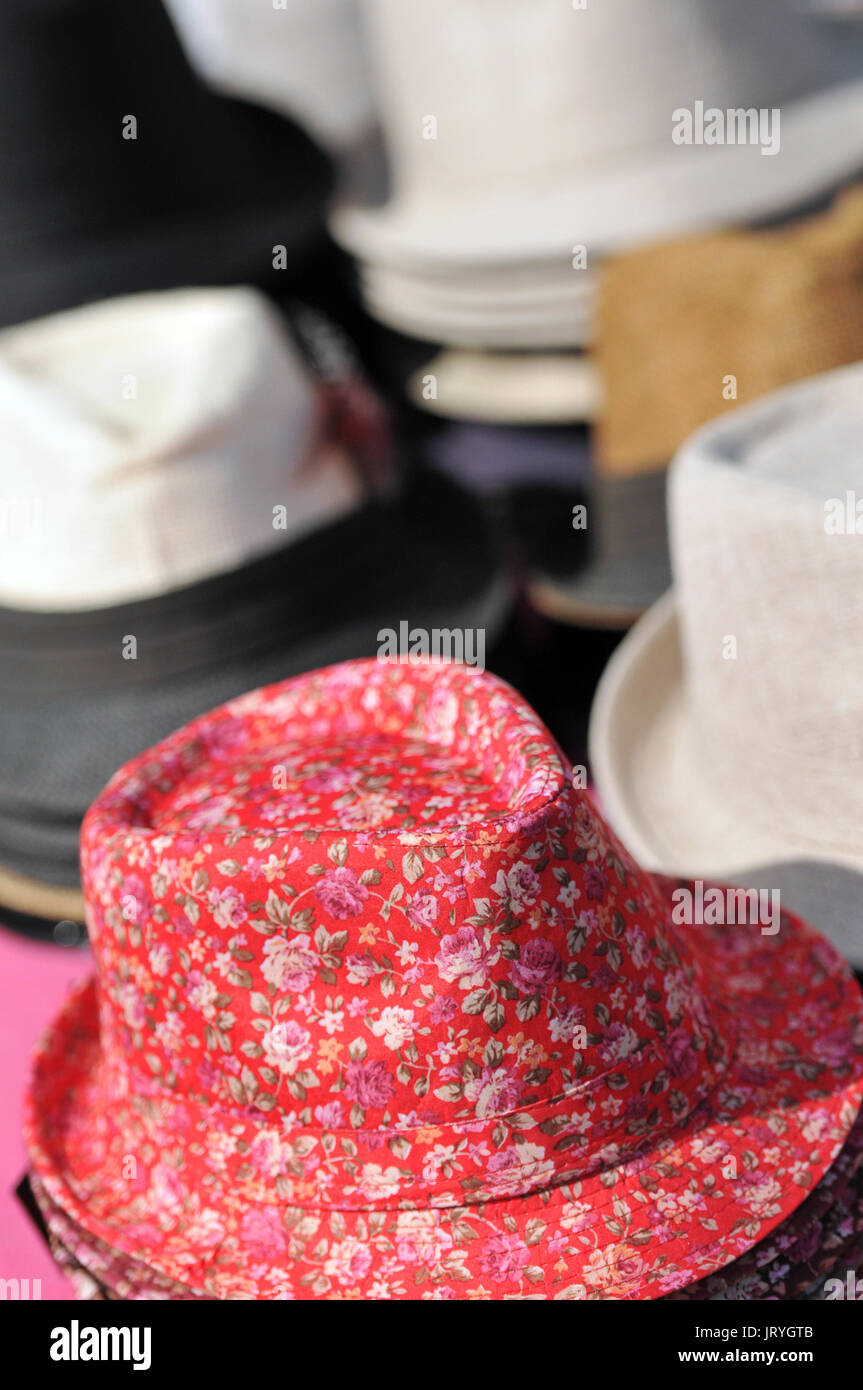 a selection variety of hats for sale trilbys and Stetsons caps and berets pork pies and bowlers at a fair or in the market pace stalls Stock Photo