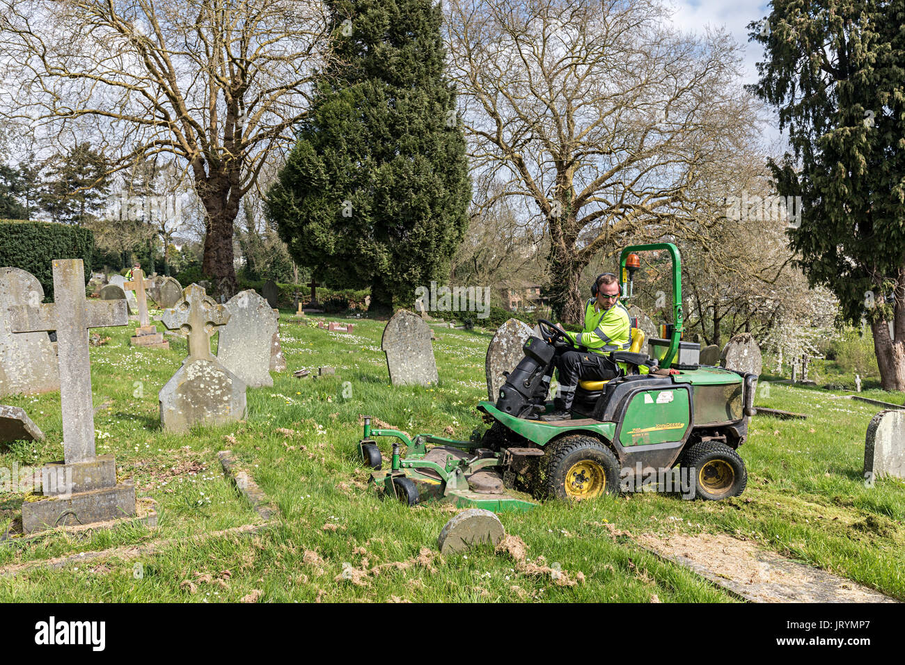 Council worker mowing grass in cemetery, Monmouth, UK Stock Photo