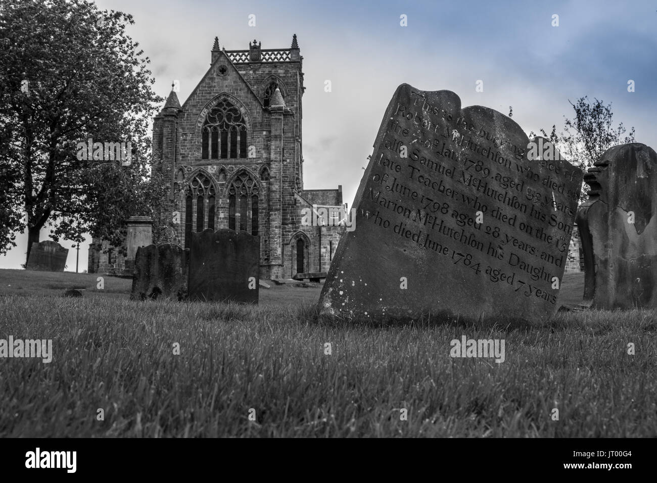 Paisley Abbey from the old graveyard abbey close showing some of the old gravestones in the graveyard next to the town hall Stock Photo