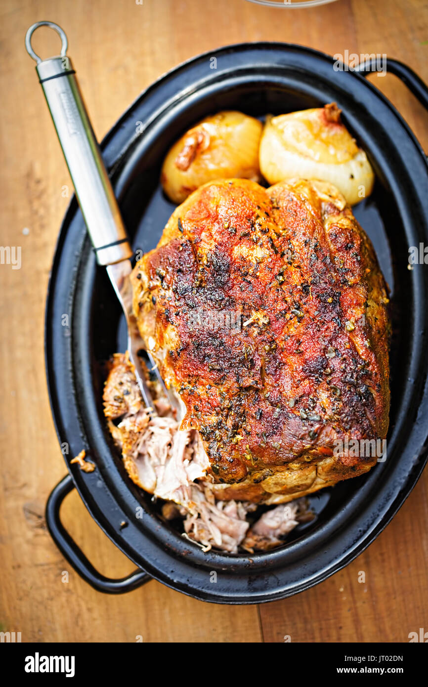 Roasted pork shoulder with onions in gravy Stock Photo Alamy