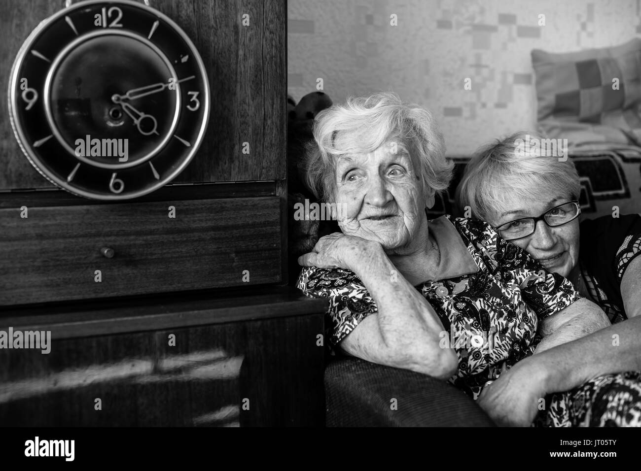 Happy elderly woman with her daughter in behind an embrace. Black and white photo. Stock Photo