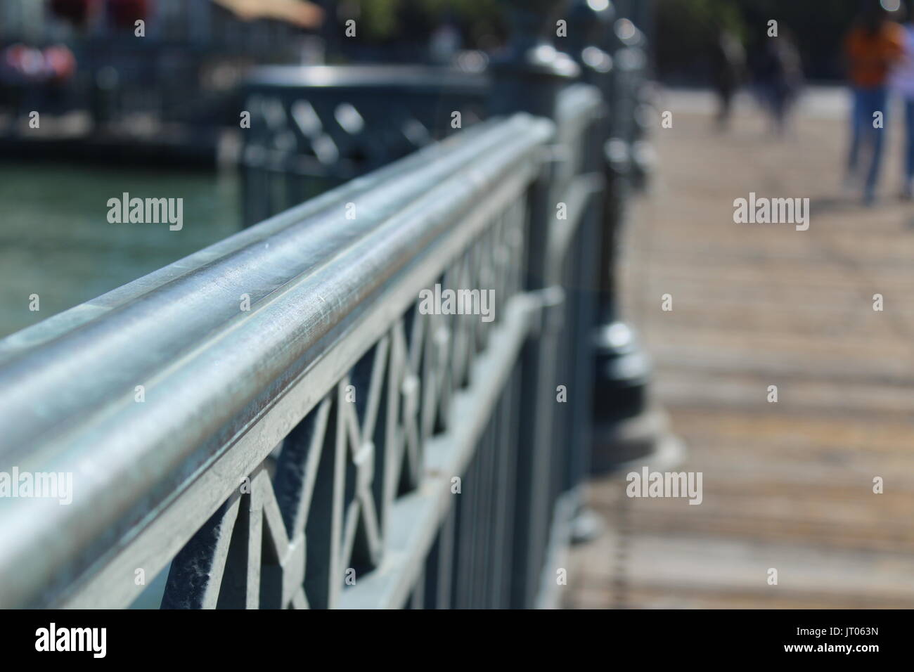 Sunny coastal pier with metal railing Stock Photo - Alamy