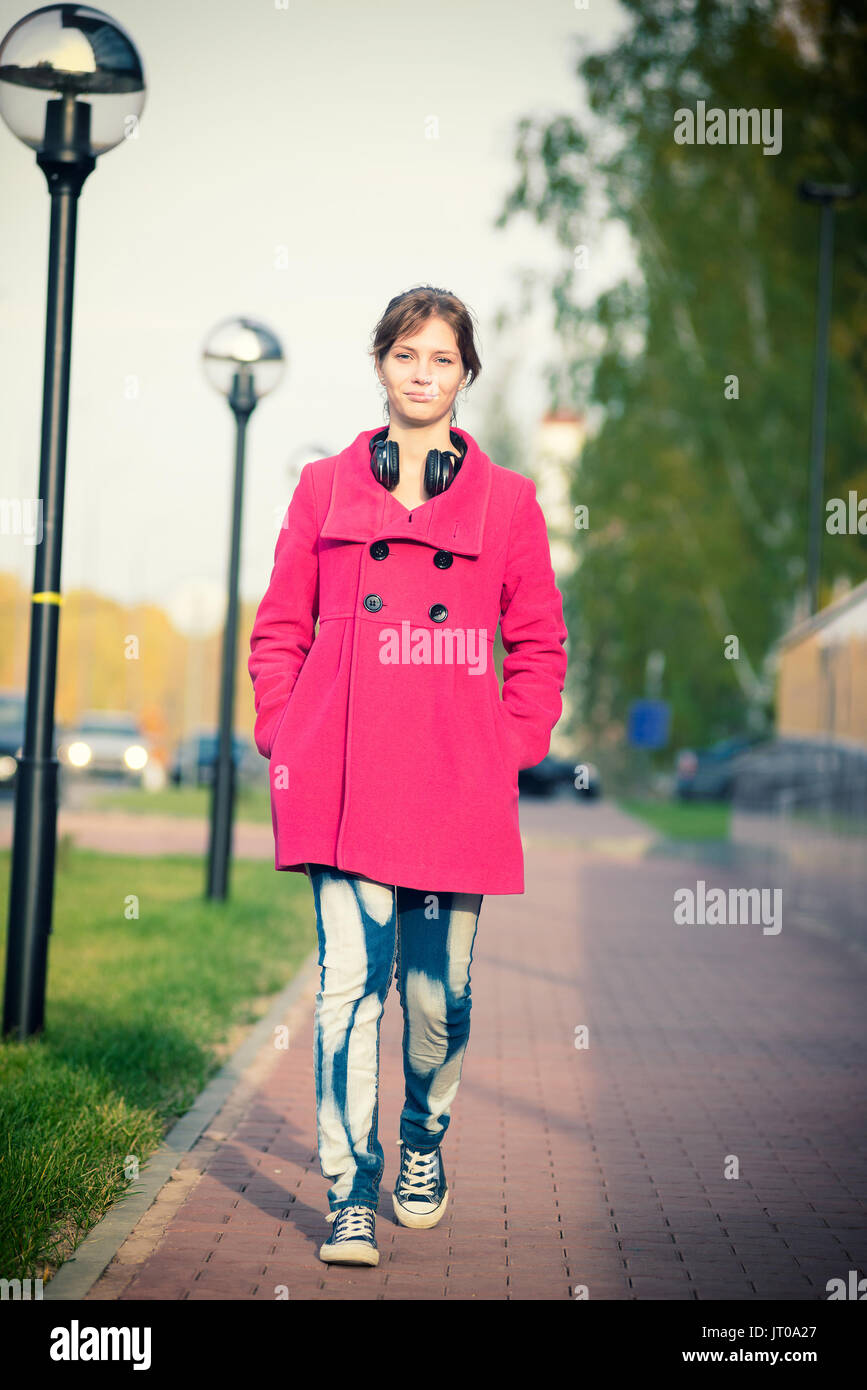 Beautiful woman in red coat walking autumn street.  Stock Photo