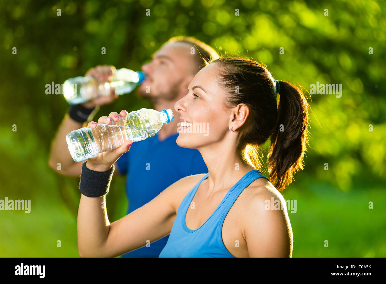 Man and woman drinking water from bottle after fitness sport exercise Stock Photo