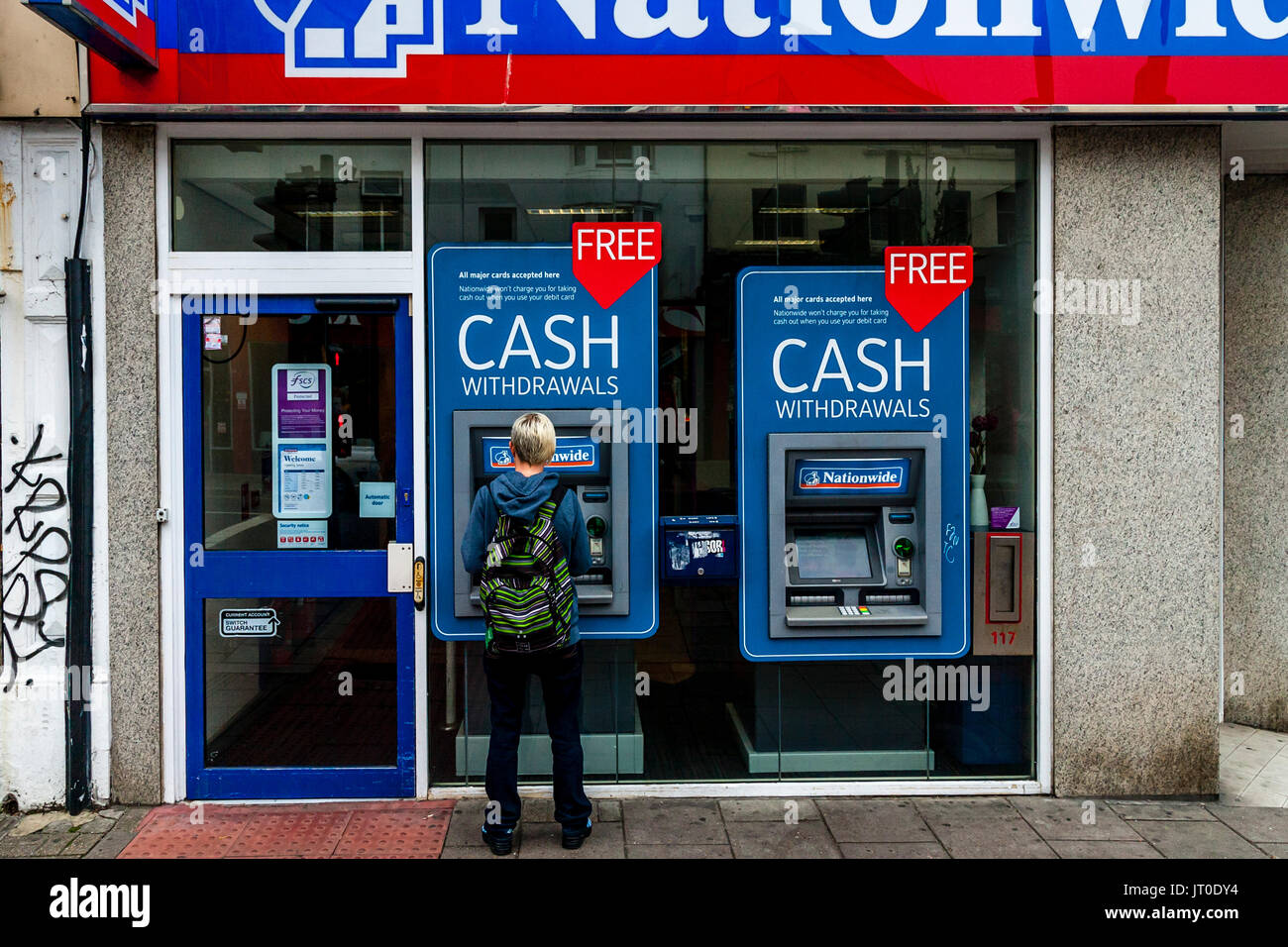 A Person Withdrawing Cash From An ATM, Brighton, Sussex, UK Stock Photo