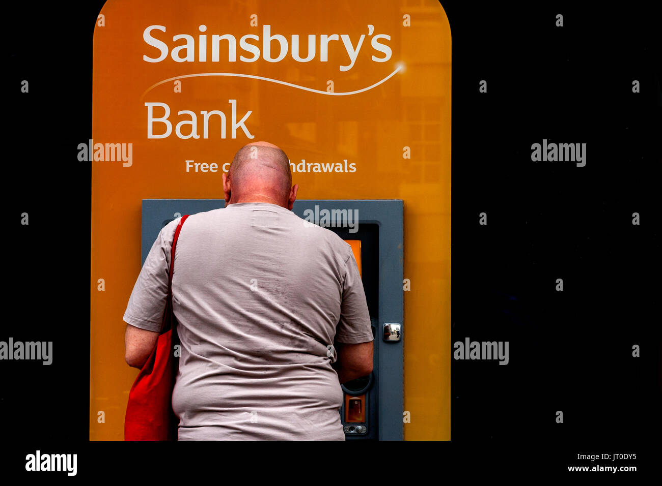 A Man Withdraws Cash From An ATM, Brighton, Sussex, UK Stock Photo