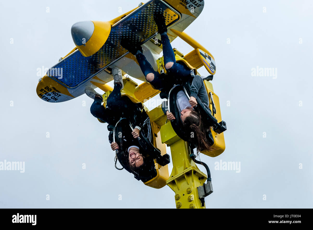 Two Young Women Enjoying A Fairground Ride In The Rain On Brighton Pier ...