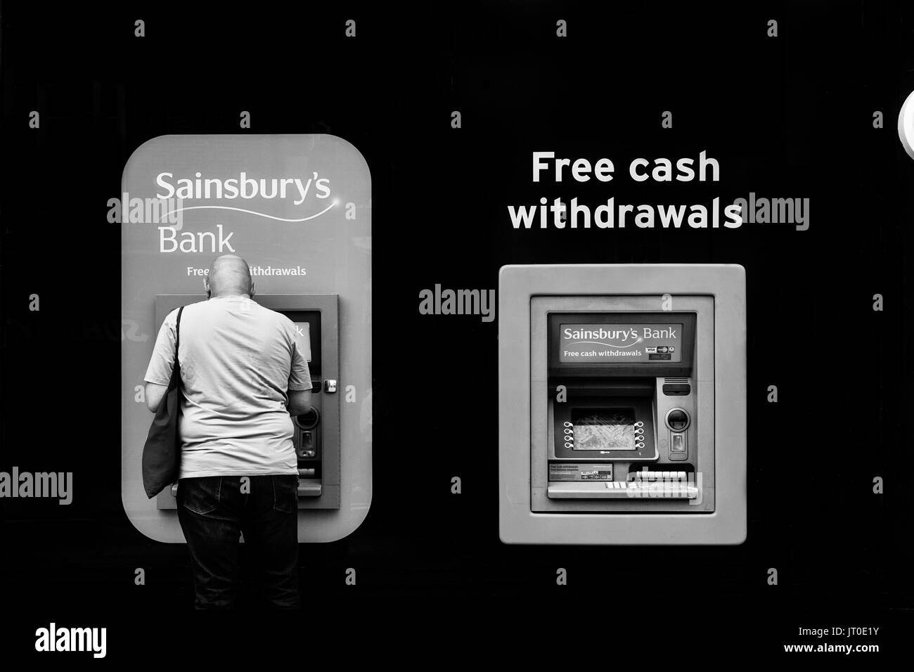 A Man Withdraws Cash From An ATM, Brighton, Sussex, UK Stock Photo