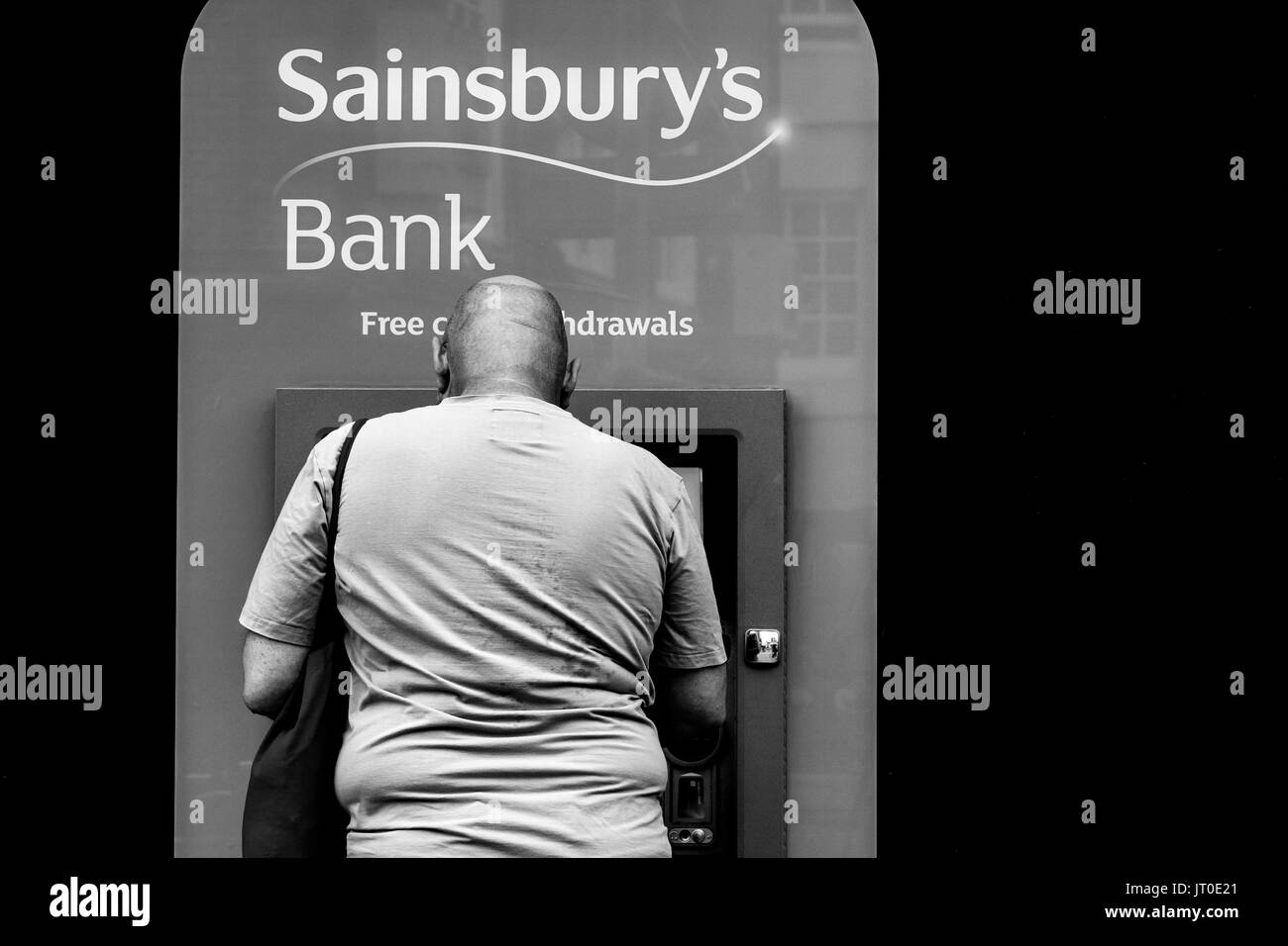 A Man Withdraws Cash From An ATM, Brighton, Sussex, UK Stock Photo