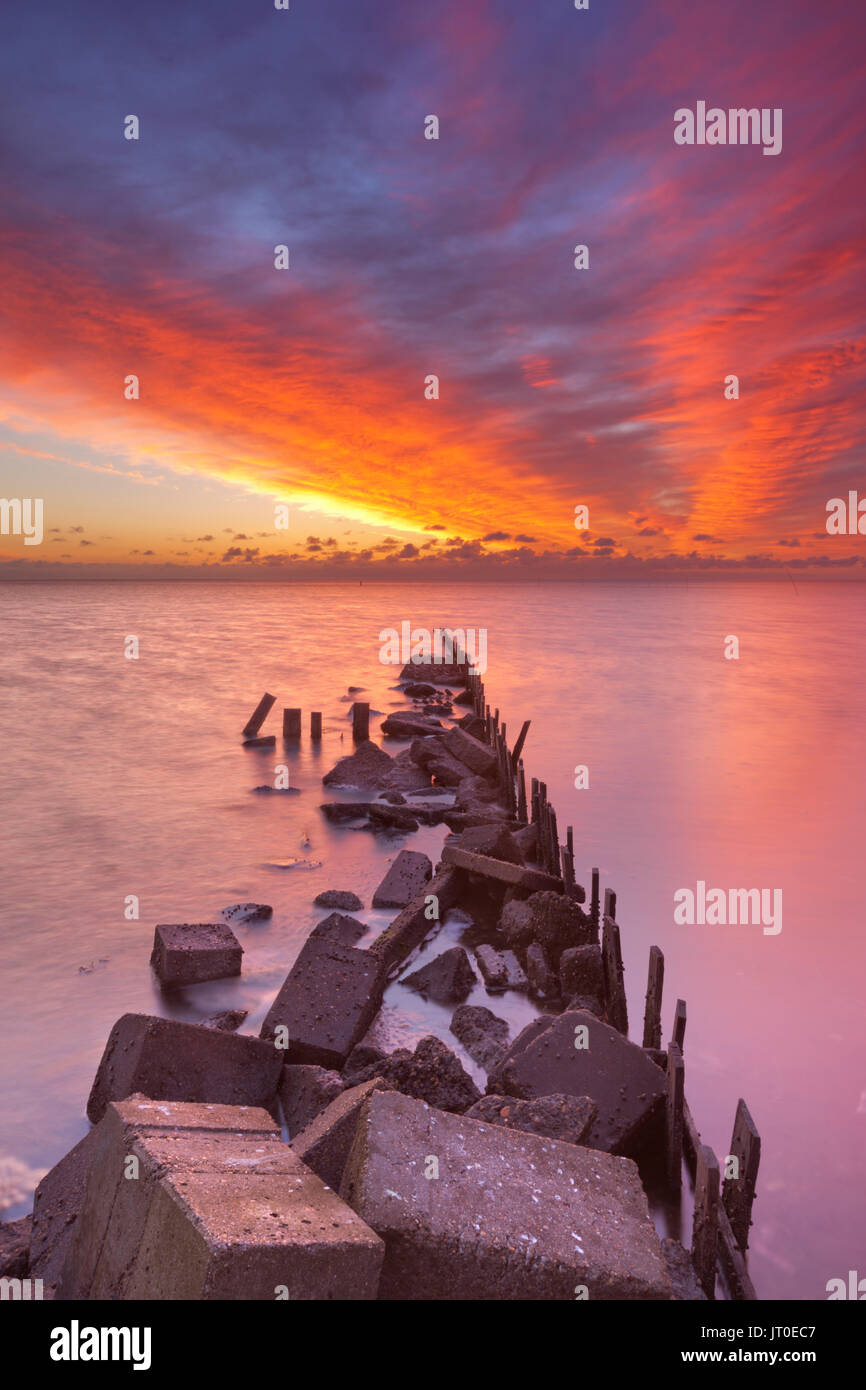 Spectacular sunrise colours over sea on the island of Texel in The Netherlands. Stock Photo