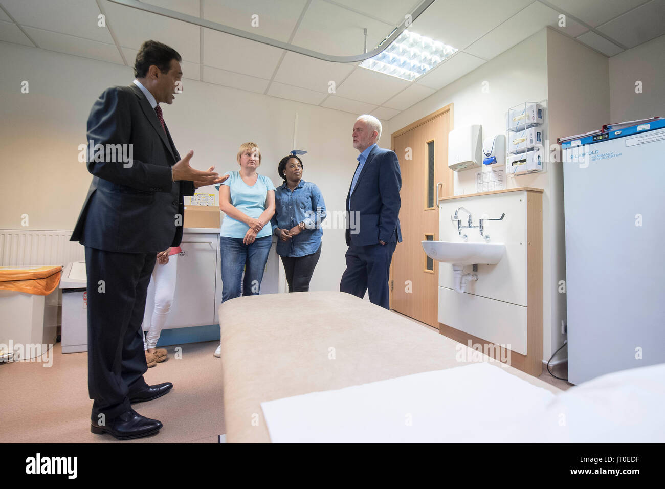 Labour leader Jeremy Corbyn speaks to Dr Onkar Sahota AM (left) and trainee phlebotomists during a visit to Somerset Family Health Practice in Southall, London. Stock Photo