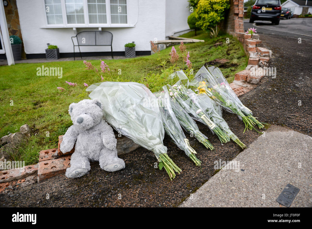Flowers and a teddy bear lay on the remains of a collapsed wall at a property in Heolgerrig, South Wales, where a one-year-old girl was killed after a Range Rover rolled into the wall causing it to collapse. Stock Photo