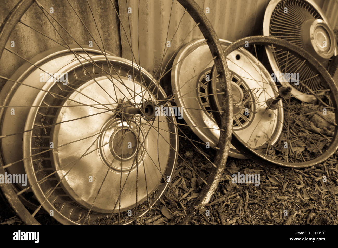 Sepia colored image, with circular shapes of antique bicycle wheels and old hubcaps from the 1960's and 1970's. Stock Photo