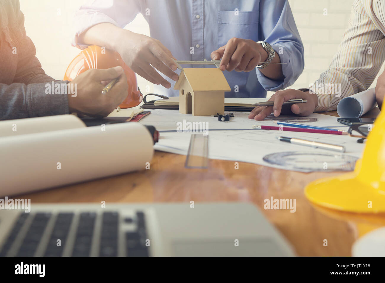 Engineer and Architect concept, Engineer Architects office team working and discussing house plan with blueprints and house model, Vintage Effect Stock Photo