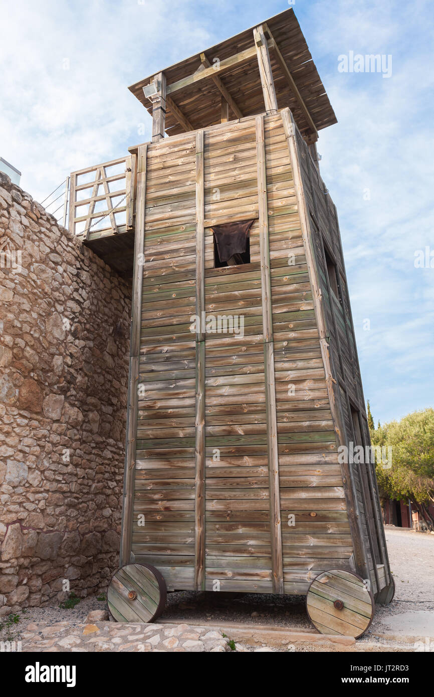 Wooden Roman Siege Tower near stone fortress wall Stock Photo