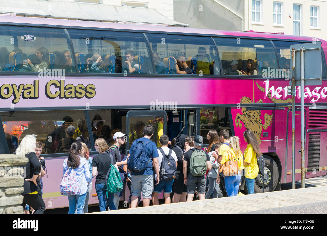 Group of students boarding a coach after a day trip. Stock Photo