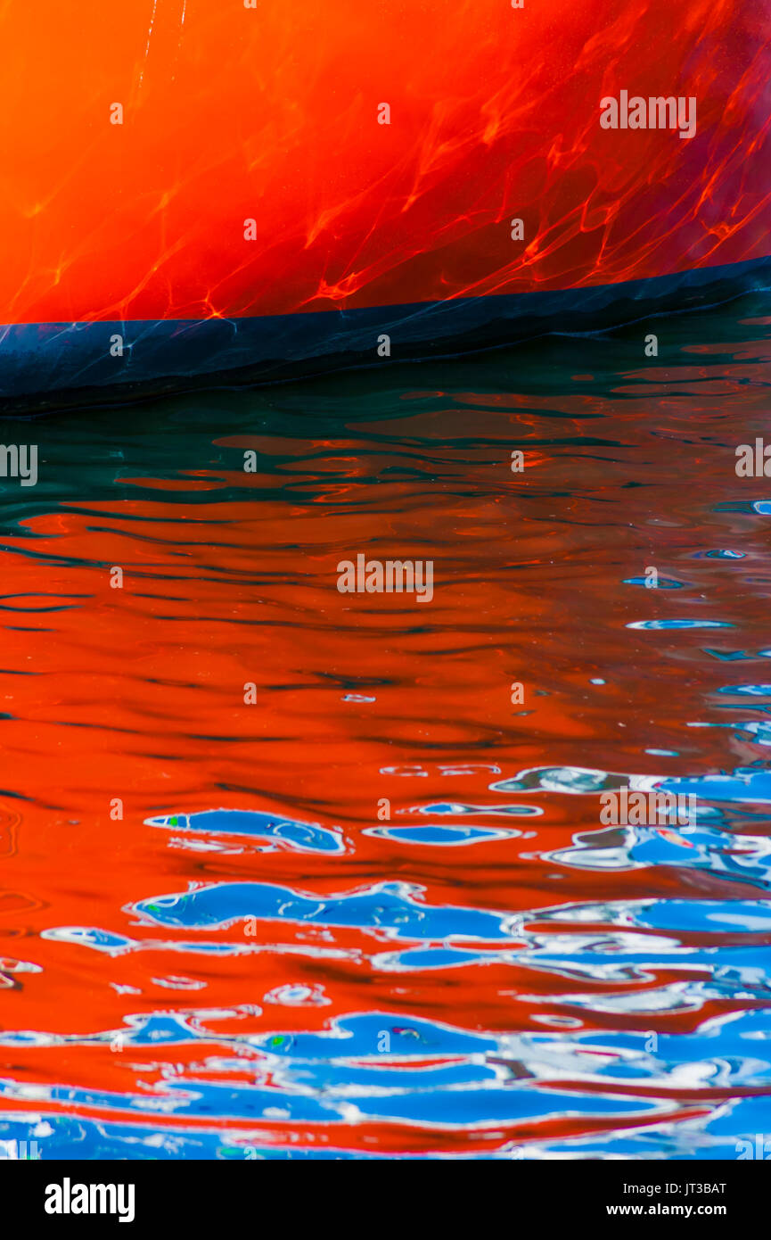 Boat hull reflected on rippled water. Stock Photo
