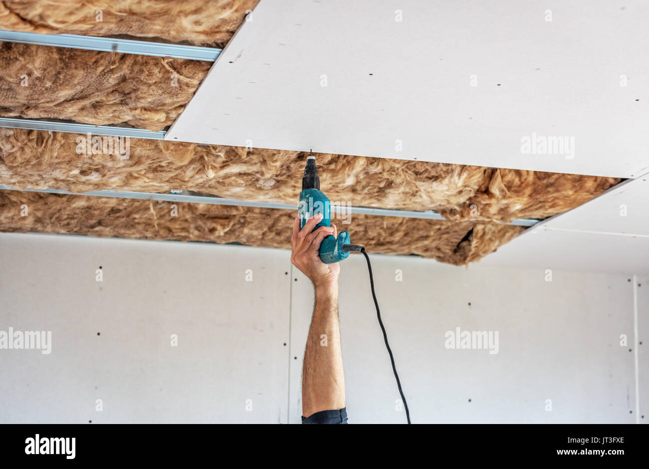 Fixing plasterboard sheets to the frame. Stock Photo