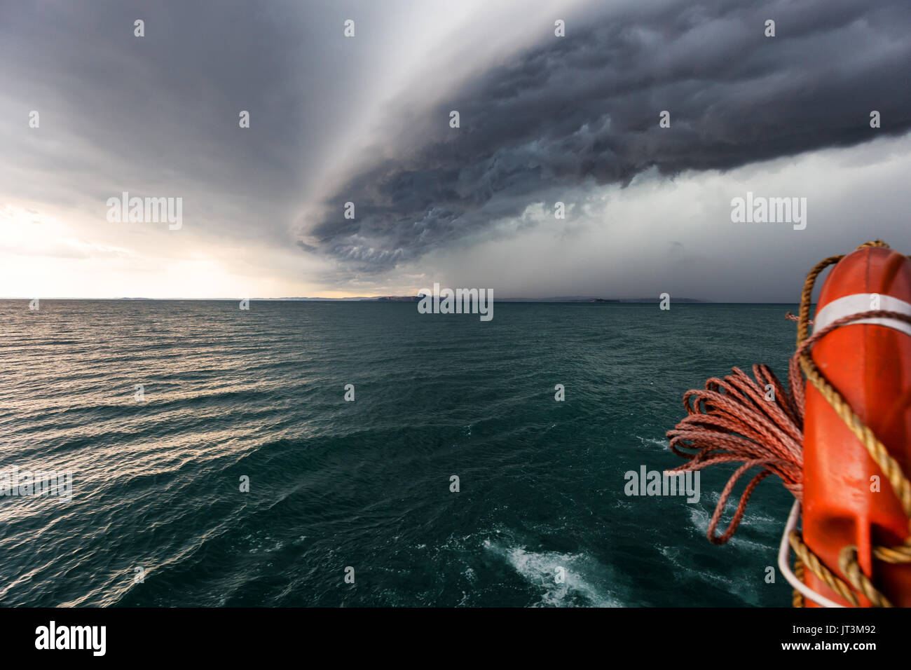 Running from fast coming storm with boat, approaching storm on lake Stock Photo