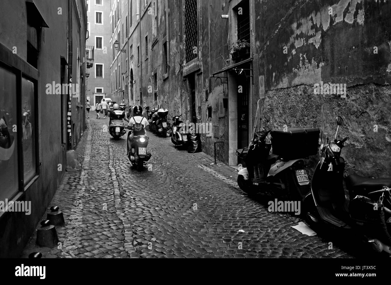 Rome Italy July 2017 - Typical narrow street with scooters in the Centro Storico district Photograph taken by Simon Dack Stock Photo