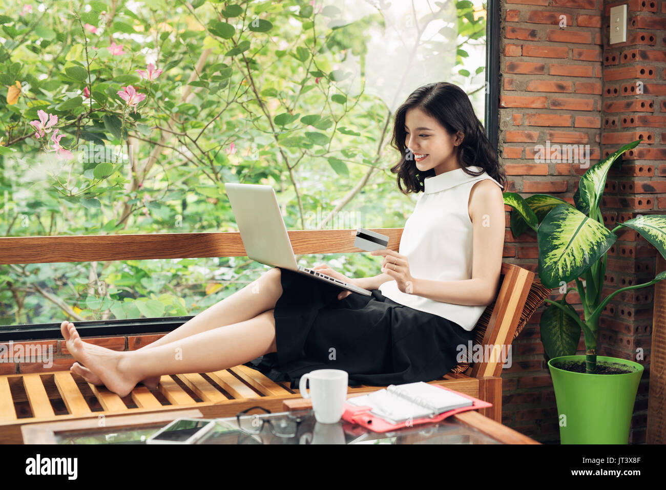 Confident young asian woman in smart casual wear using laptop Stock Photo