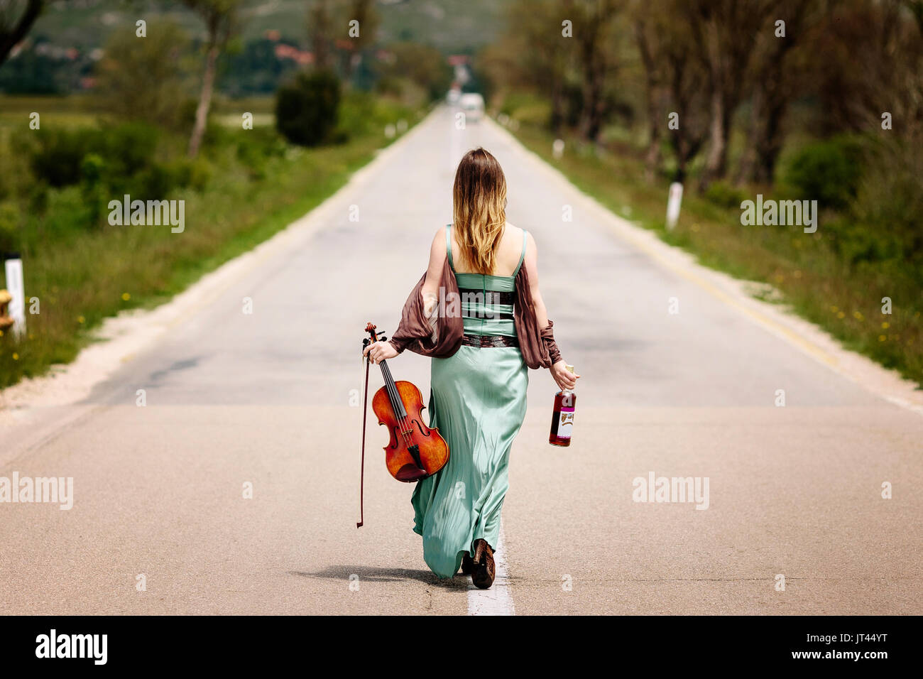 Beautiful female viola player walking along the highway Stock Photo Alamy