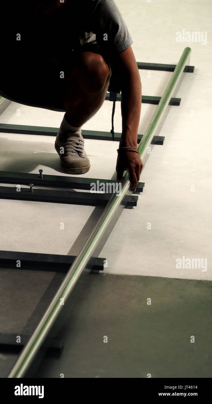 Behind the scenes of production team setting dolly track for camera equipment and video shooting in a big studio. Stock Photo