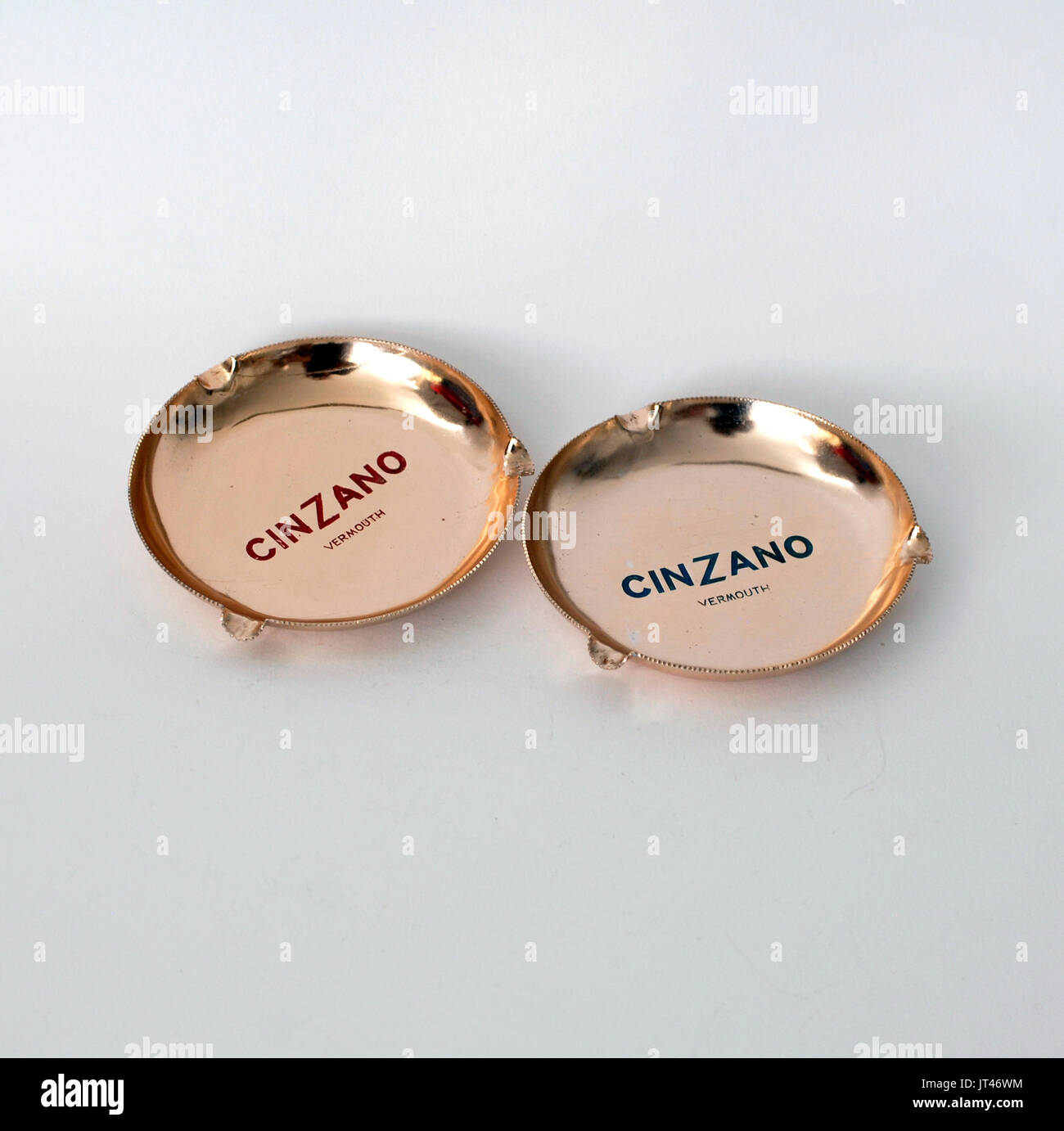 Two vintage ashtrays publicity logo Cinzano Vermouth, made by anodized aluminum, colors copper, blue and read. Round Stock Photo