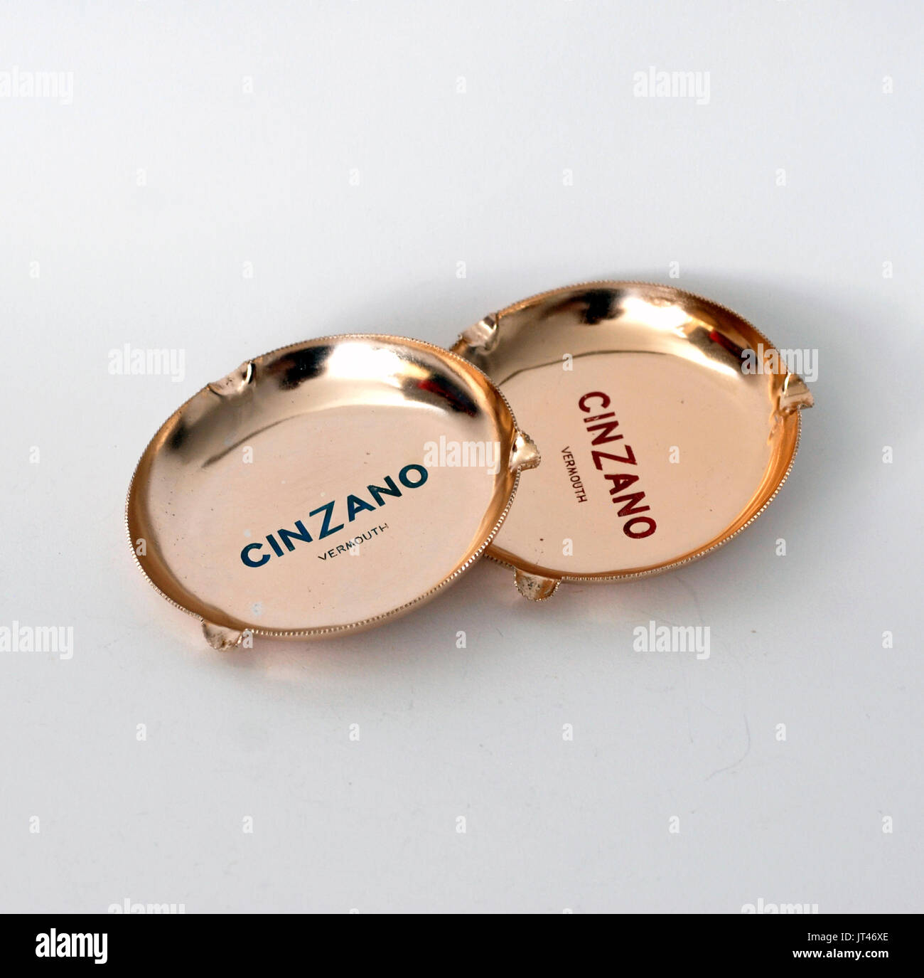 Two vintage ashtrays publicity logo Cinzano Vermouth, made by anodized aluminum, colors copper, blue and read. Round Stock Photo