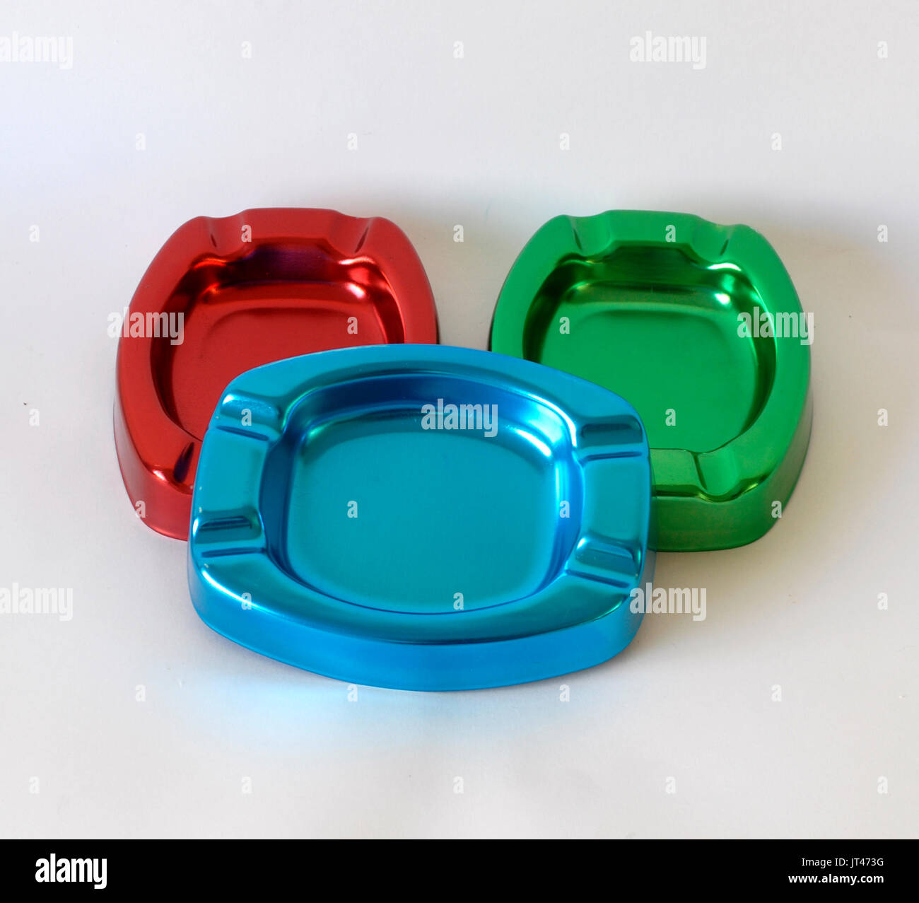 Three colorful ashtrays made by anodized aluminum, colors blue, red and green. For cigarettes smokers. Smoke Cigarette Stock Photo