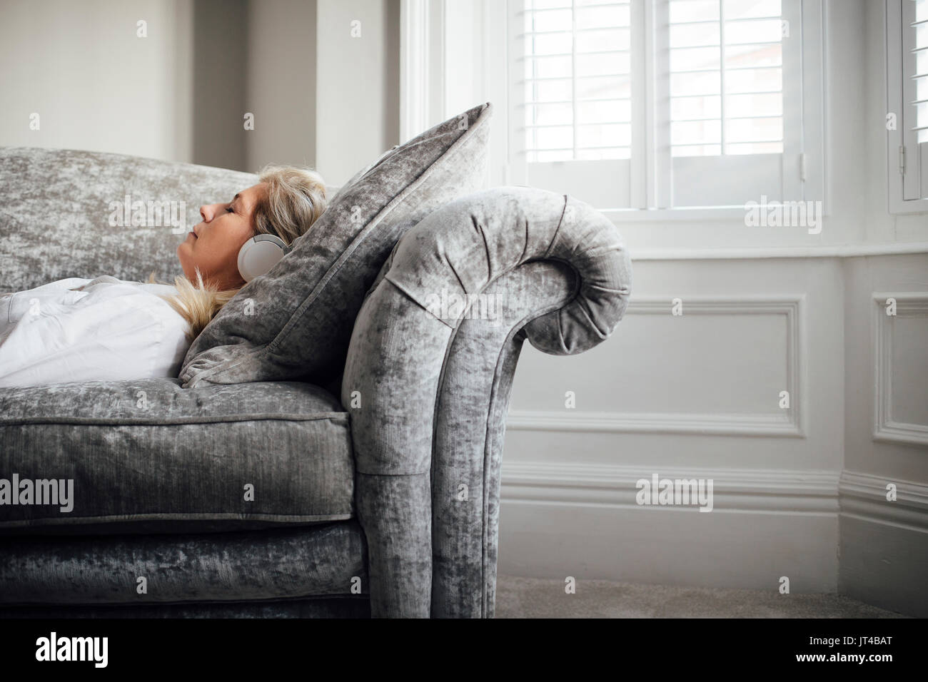 Mature woman lying on sofa hi-res stock photography and images - Alamy
