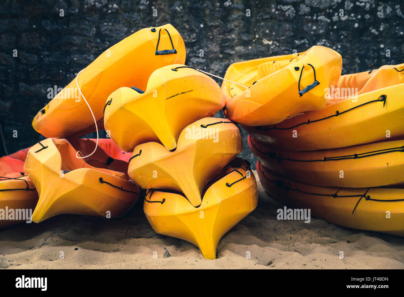 Stacked orange kayaks on a beach Stock Photo Alamy