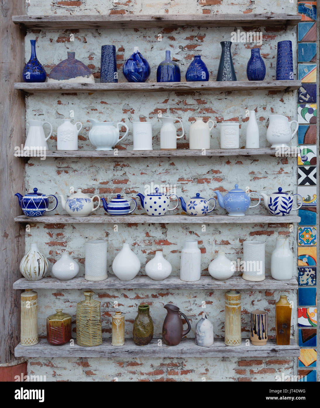 Ceramic vases are placed on shelves next to walls to decorate the house