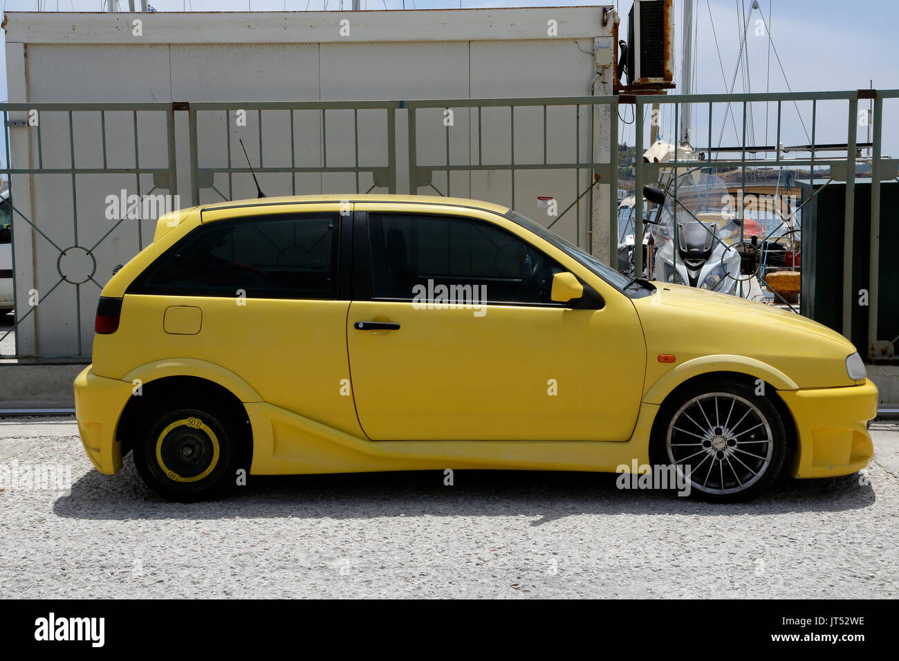 Lavrio Port Attica Greece bright yellow Seat Ibiza car parked by Port Stock Photo