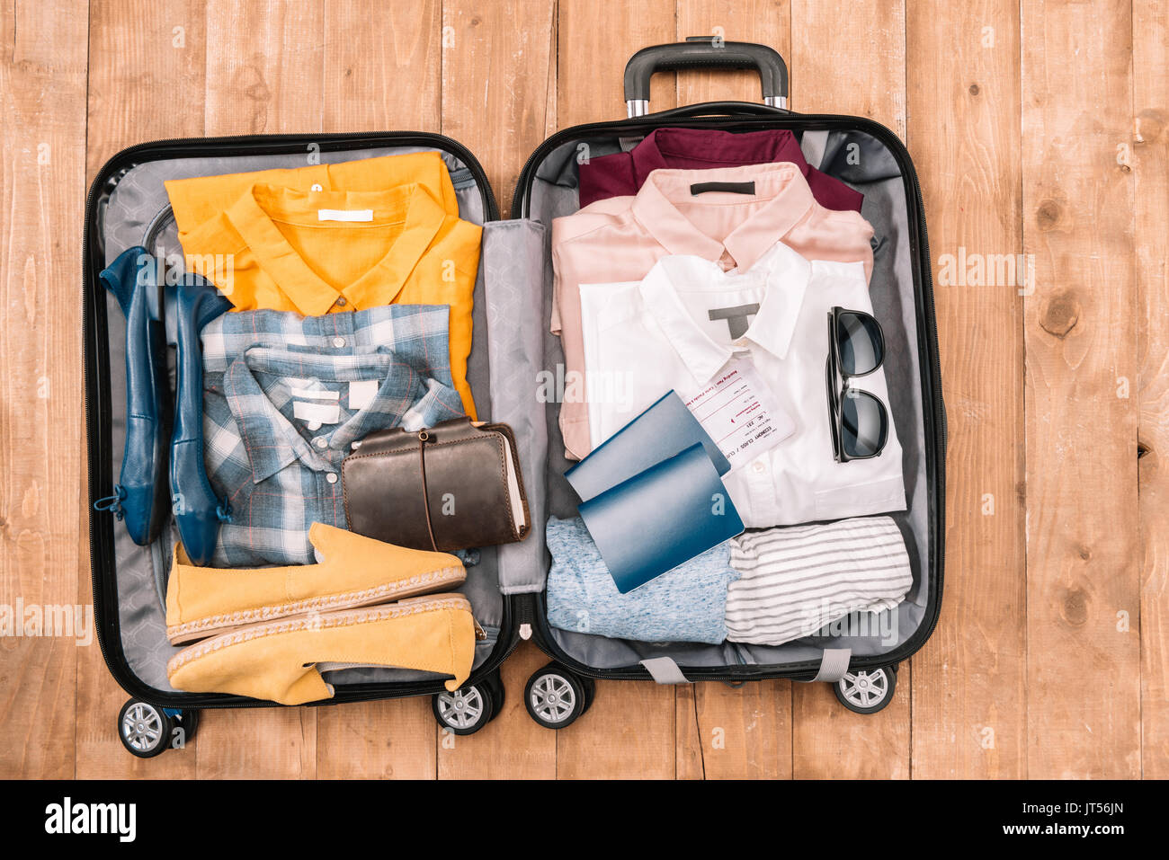 Overhead view of traveler's accessories organized in open luggage on