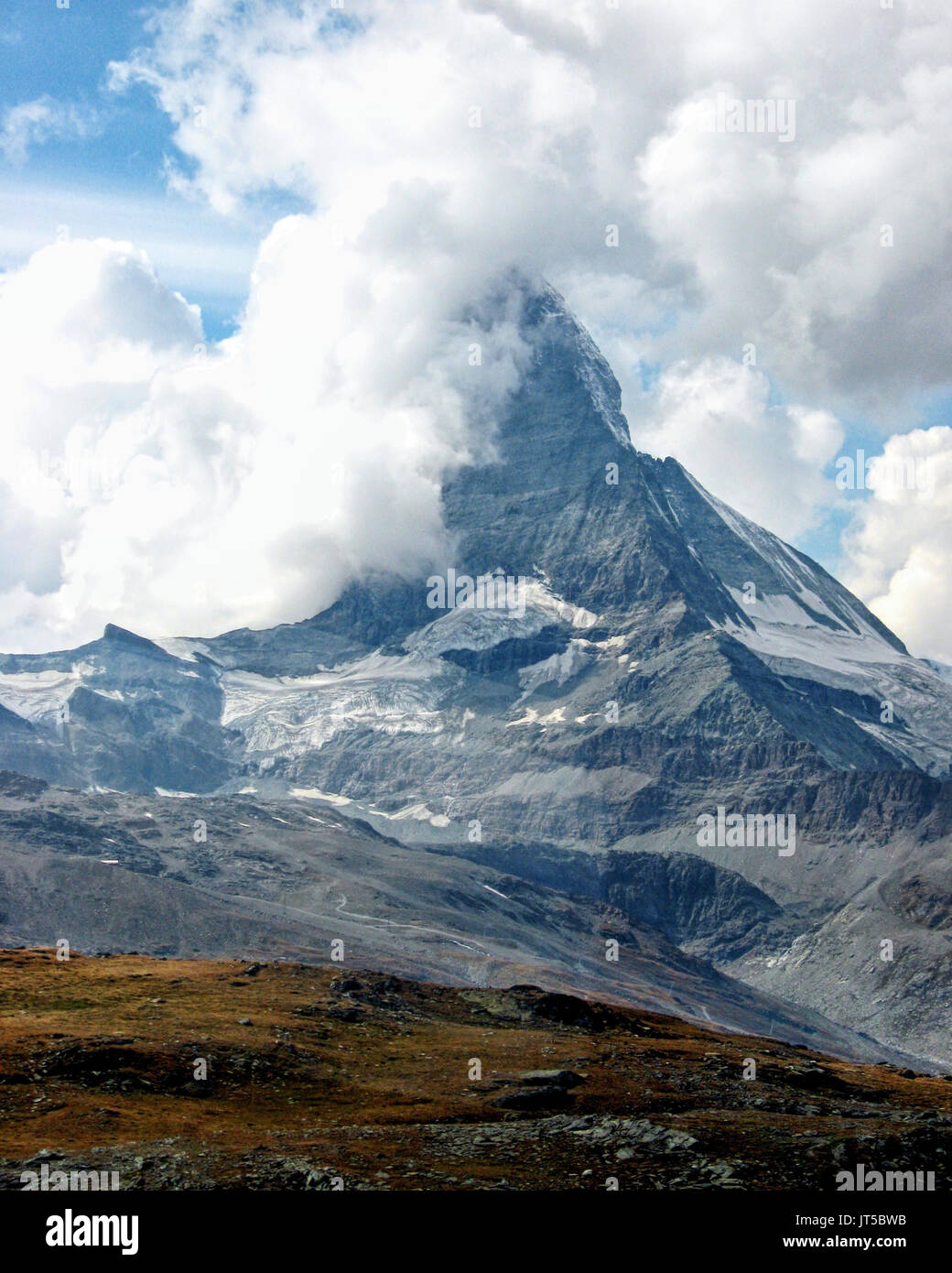 The famous Swiss Matterhorn mountain is partially hidden by beautiful clouds. Stock Photo