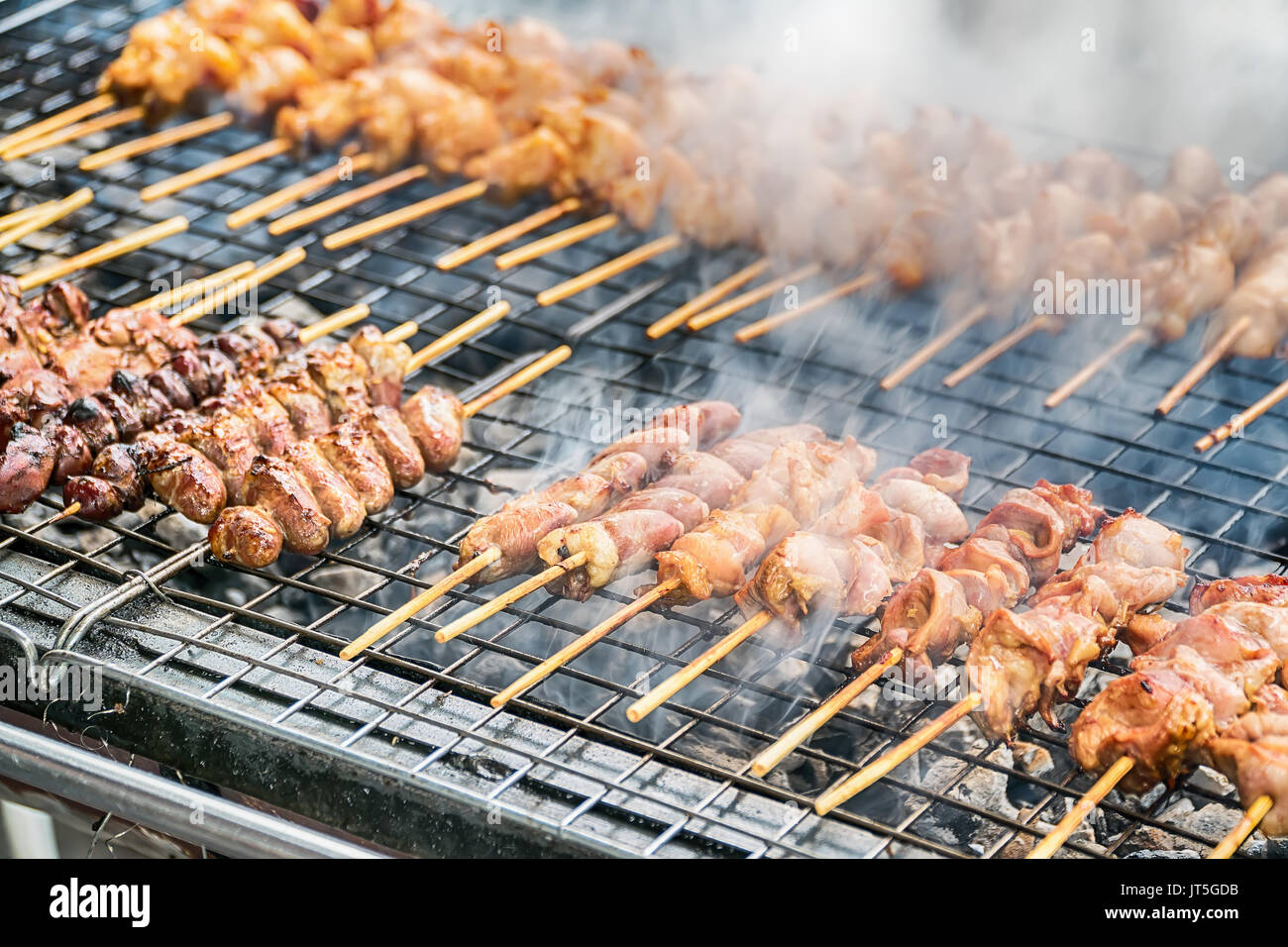 Grilling marinated meat on a charcoal grill Stock Photo - Alamy
