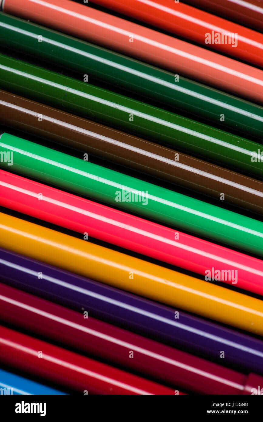 Colorful pens with caps closeup, red background Stock Photo by