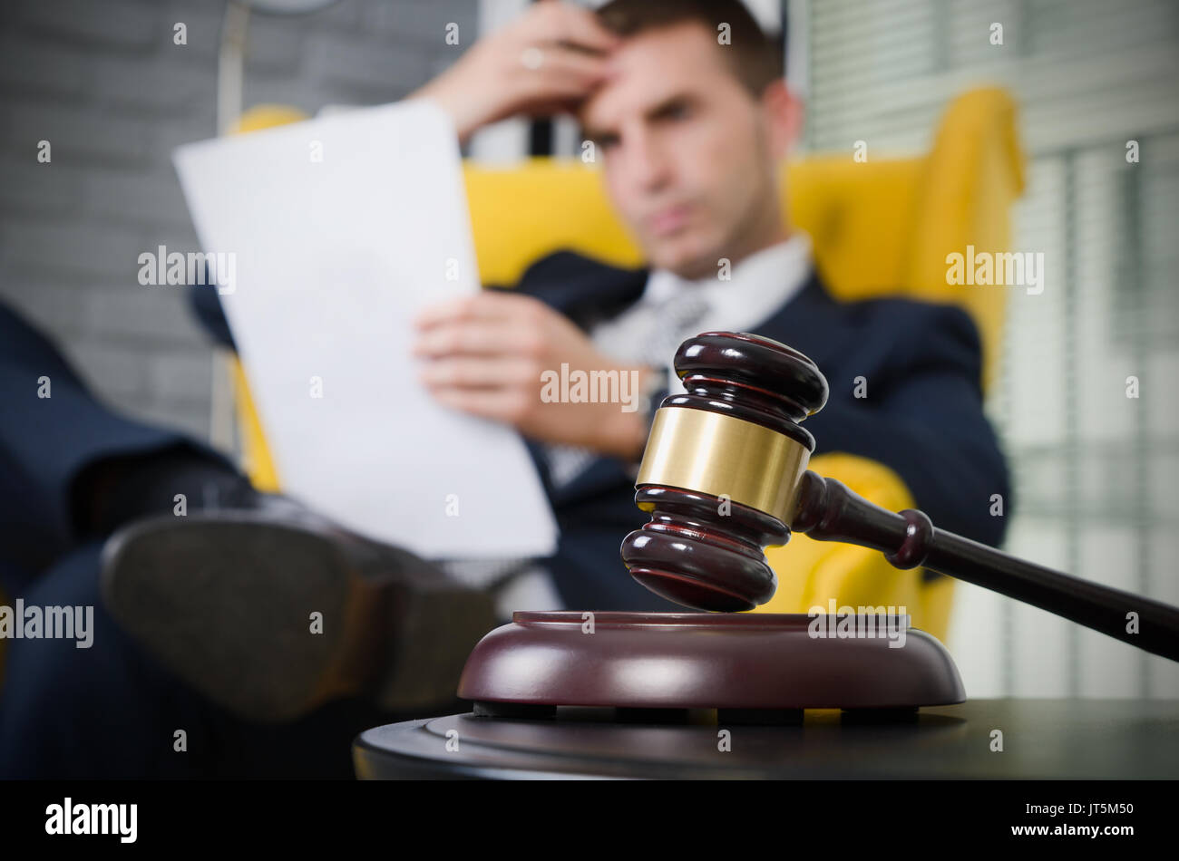 Wooden gavel, working lawyer in background. attorney business judgment
