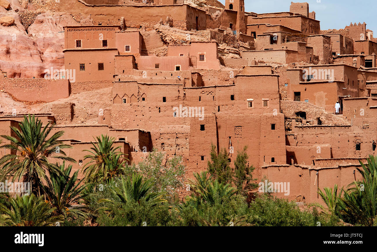 A solitary white figure stands in the Moroccan town of Ait Benhaddou. With its kasbahs and earth-clay buildings it is a UNESCO world heritage site. Stock Photo