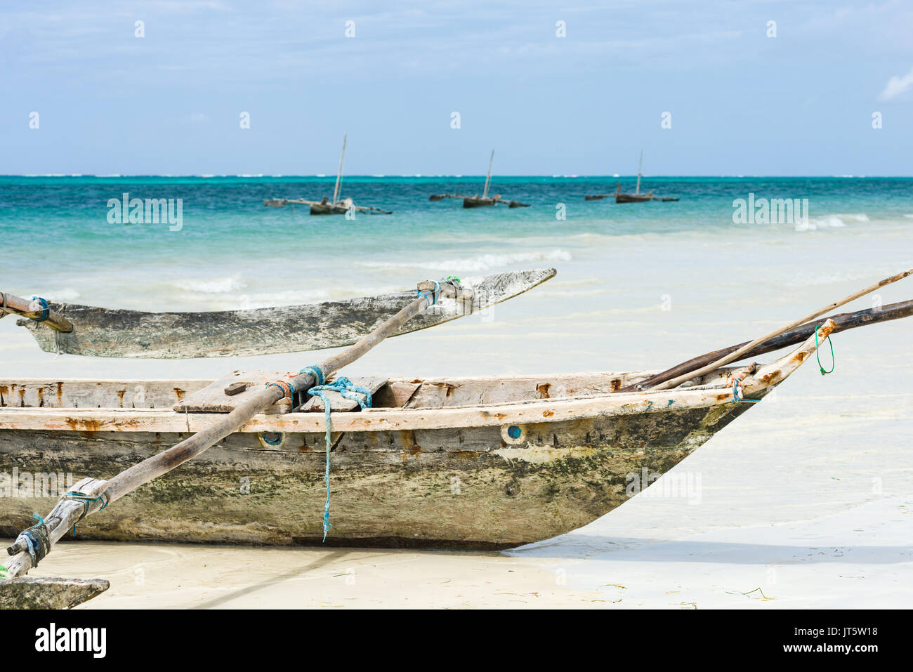 Traditional dhow fishing boats by shoreline and in ocean, Diani beach, Kenya Stock Photo