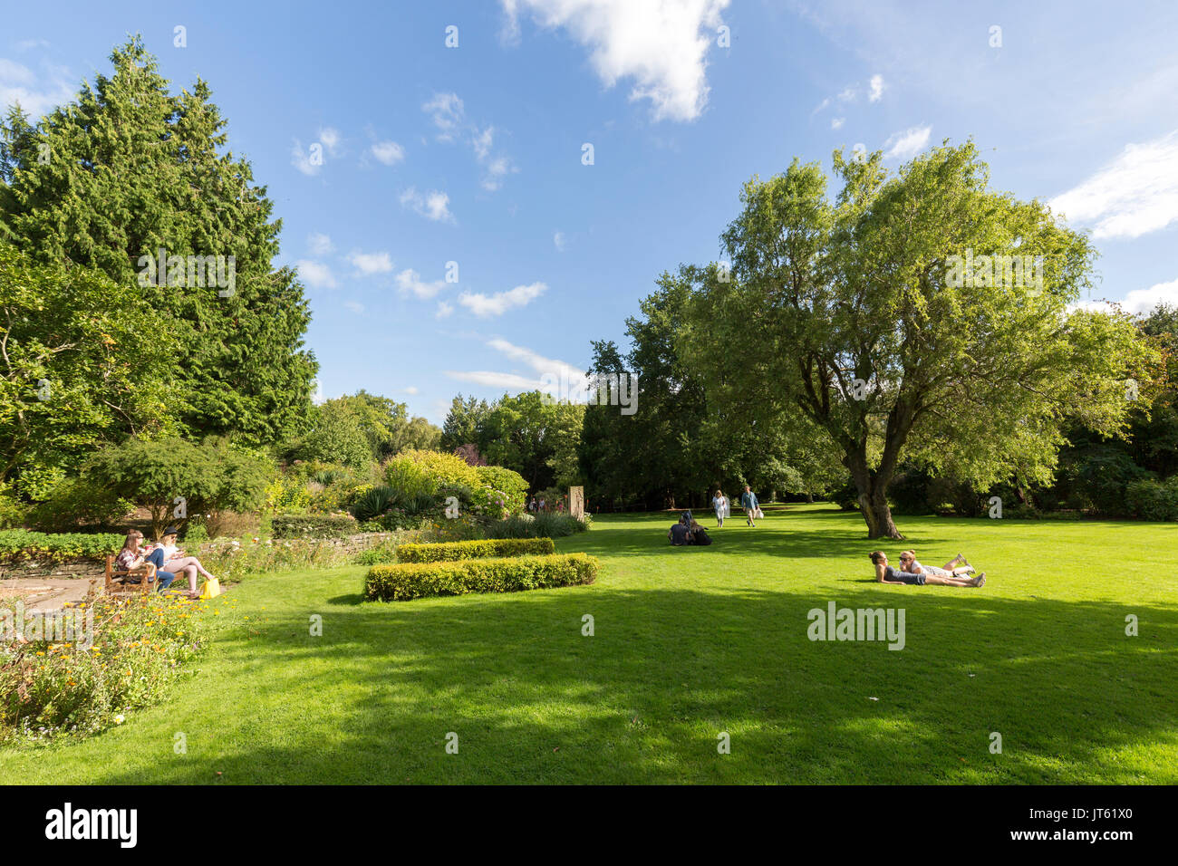 People sitting in the sun in public park, Linda Vista Gardens, Abergavenny, Wales, UK Stock Photo