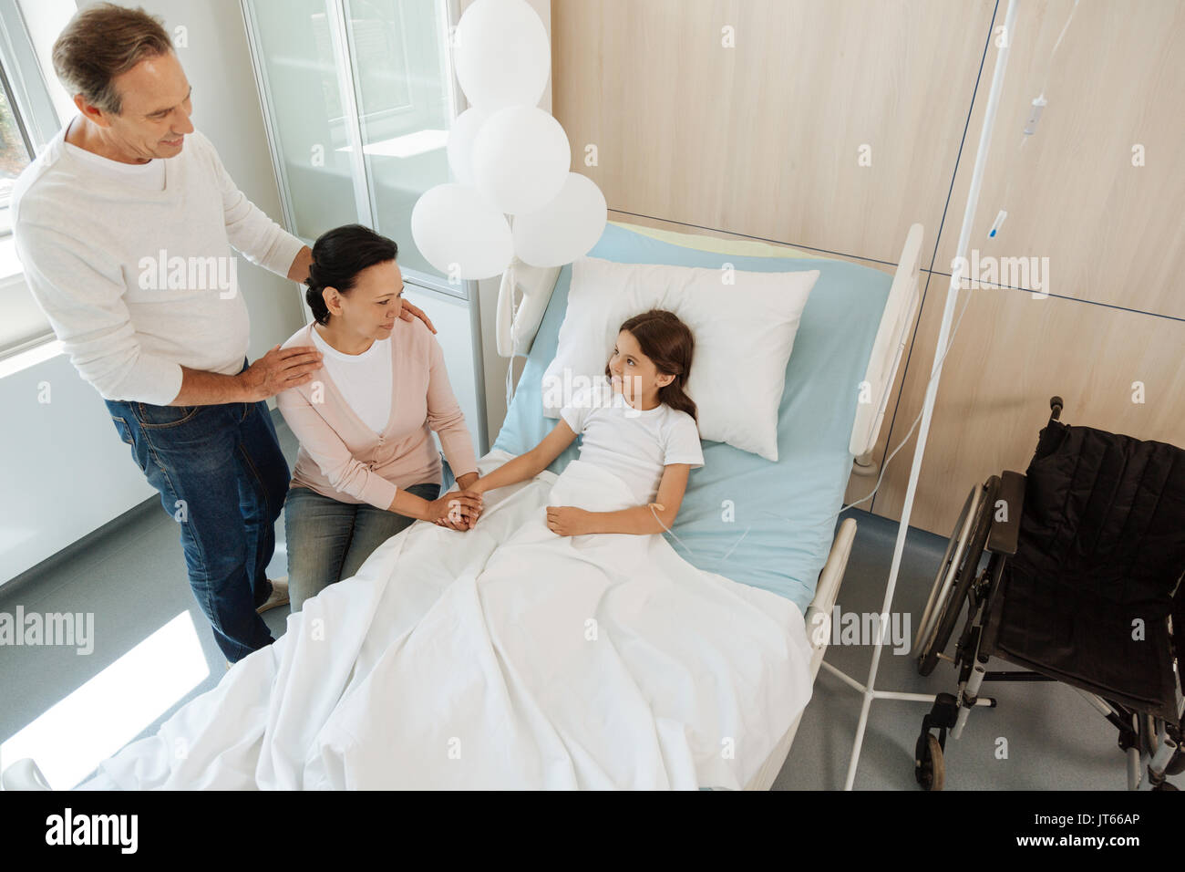Сын навестил отца. Навещать родителей. Дочь навещает отца в больнице. Девочка сидя на больничный койке около отца.