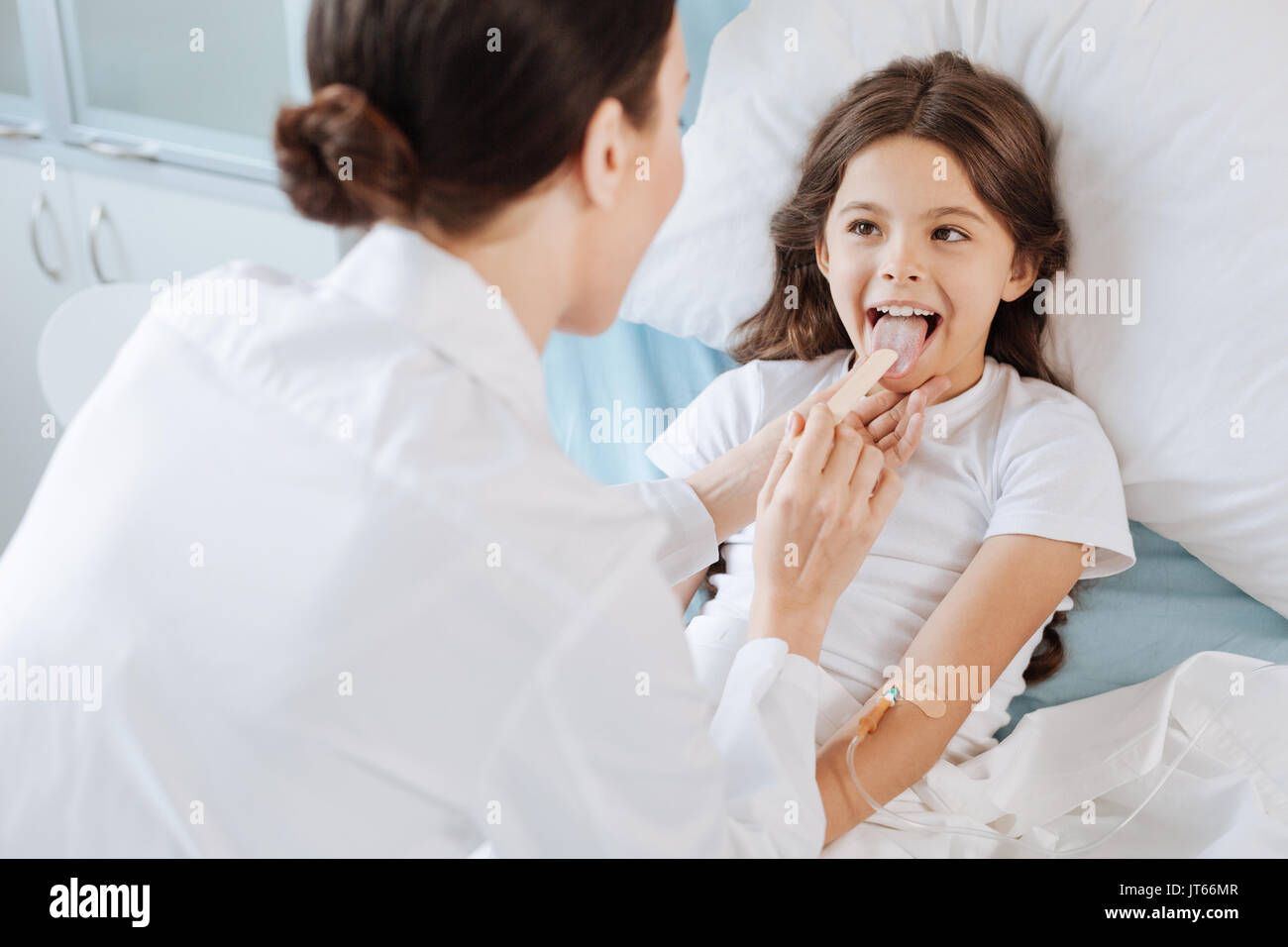 Pleasant cheerful girl being examined by a doctor Stock Photo